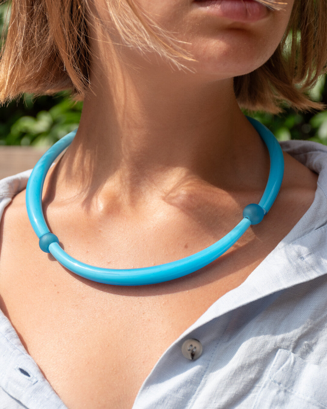 Person wearing a blue glass necklace