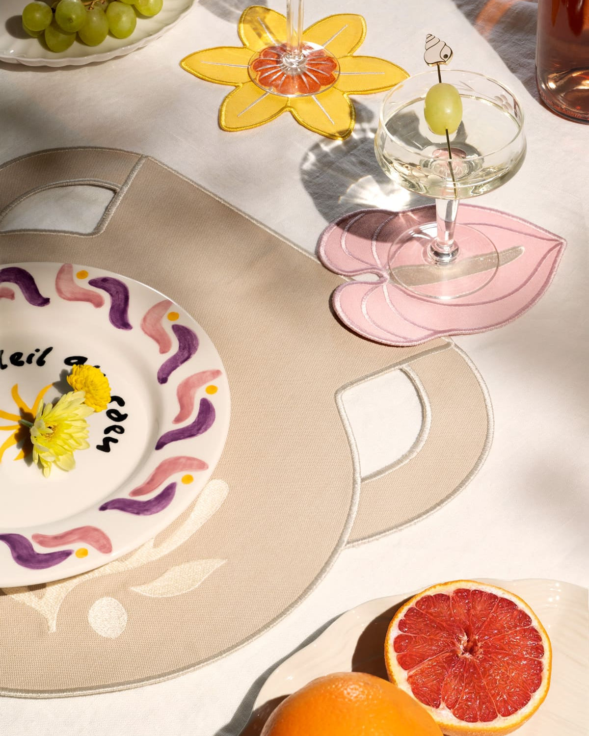 A table with grapes, grapefruit, cocktails, and Octaevo Daffodil Coasters (Set of 4) on a linen-cotton white cloth.