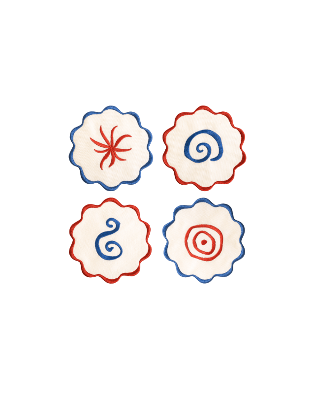 The Amalfi Coasters set by Octaevo features 4 white linen-cotton coasters with blue or red scalloped swirl embroidery.