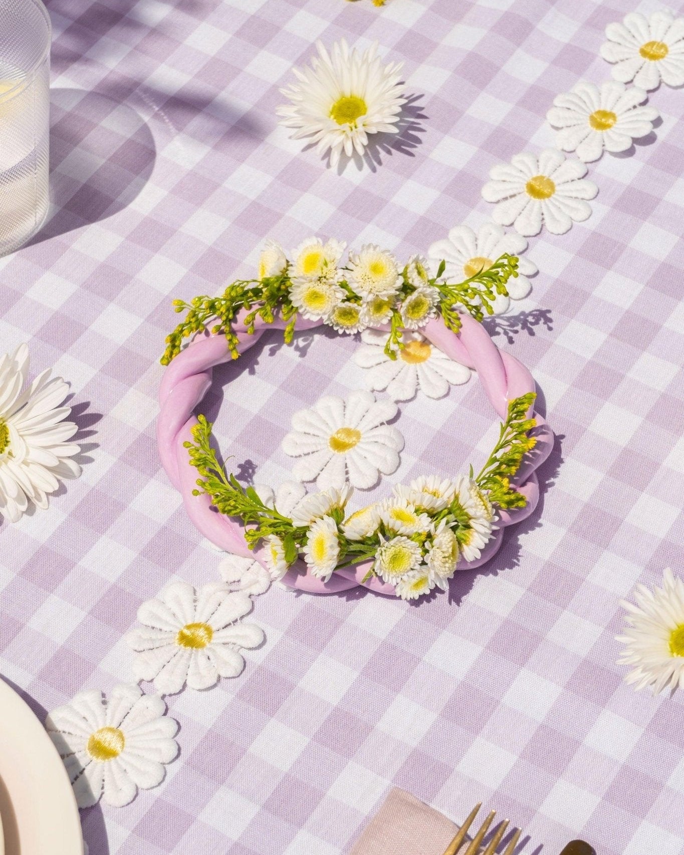 The OCTAEVO Sicilia Ceramic Trivet rests on a purple gingham tablecloth beside decorative wreath accents.