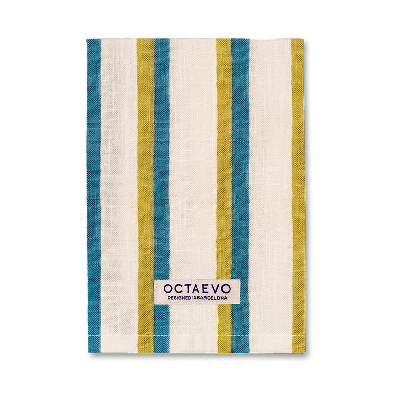 Riviera napkin in Blue, hand block printed cotton with wide teal and olive stripes on cream, OCTAEVO label.