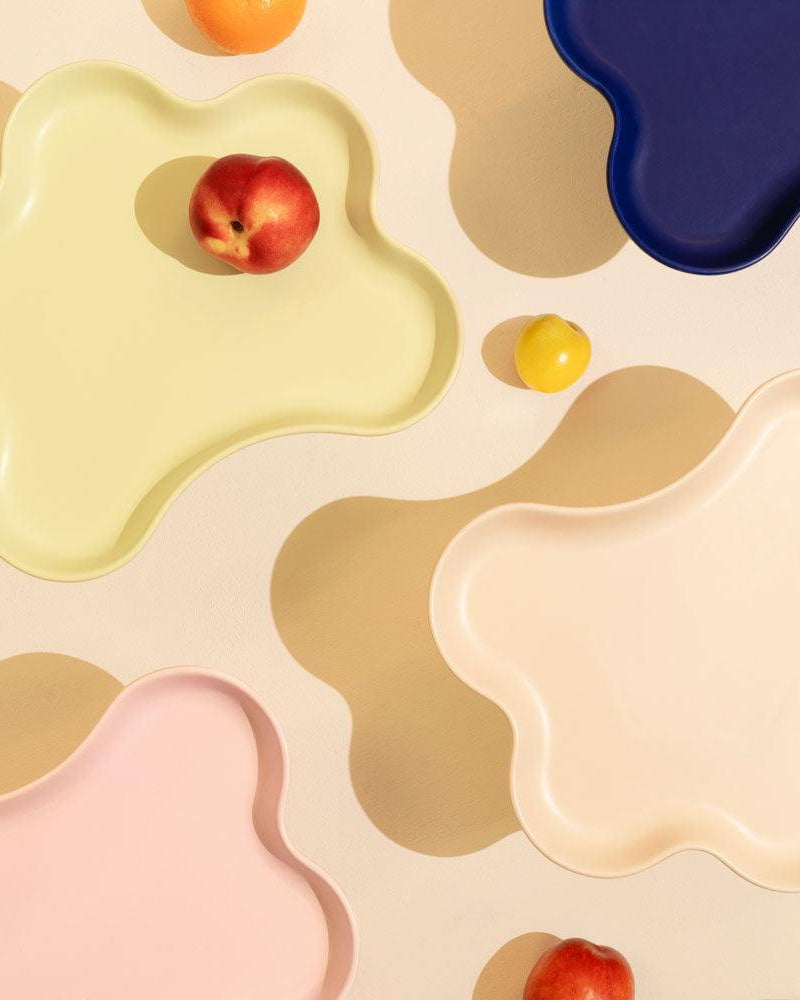 The Octaevo Templo High Tray in pastel tones makes a modern centerpiece when filled with peaches and oranges.