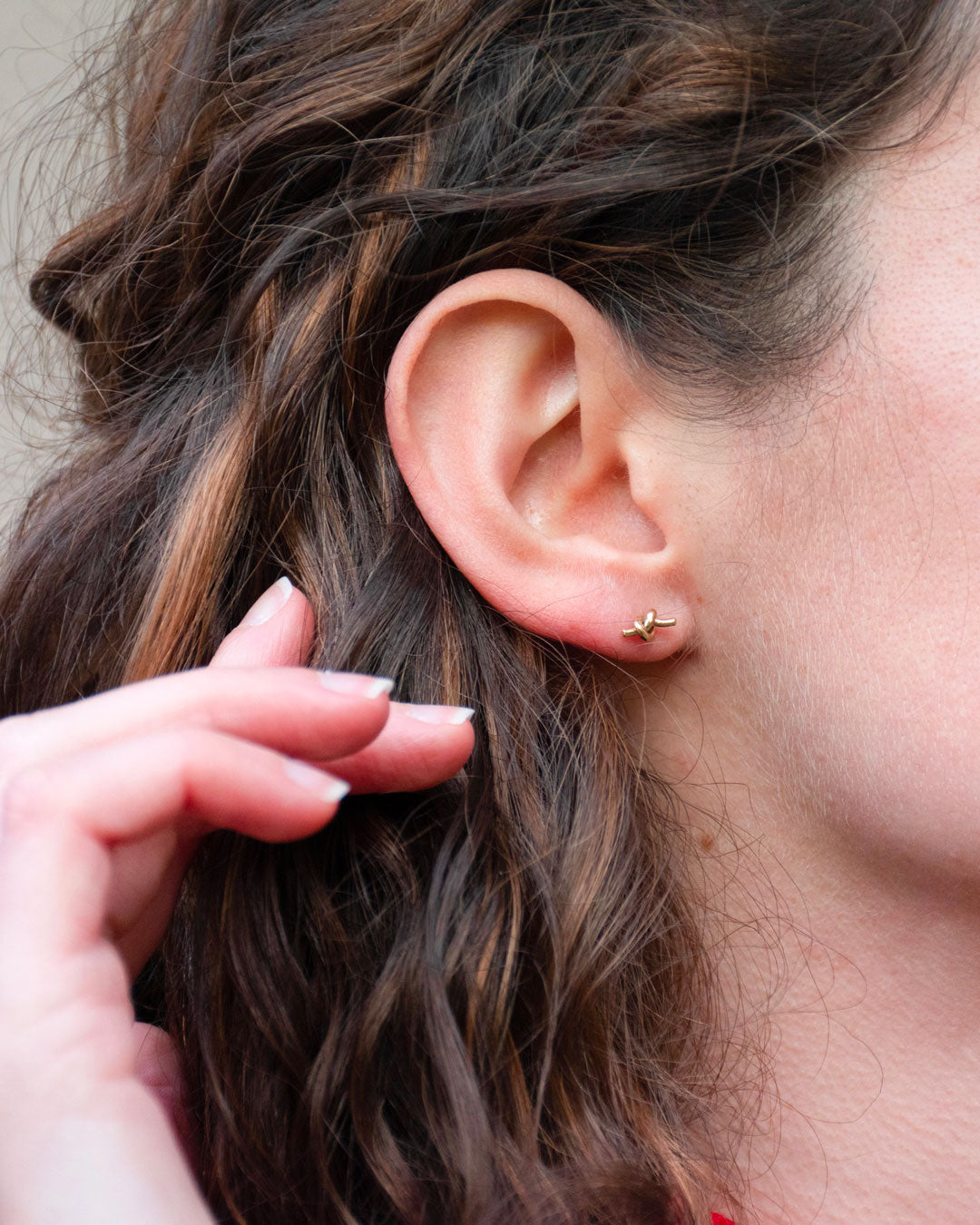 Detail of golden knot earrings worn